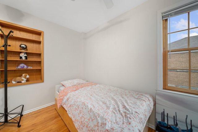 bedroom featuring wood finished floors, baseboards, and ceiling fan