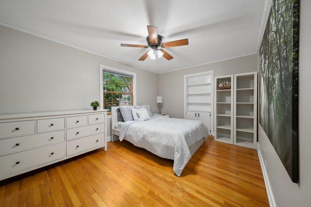 bedroom featuring ceiling fan, light wood-style flooring, and ornamental molding