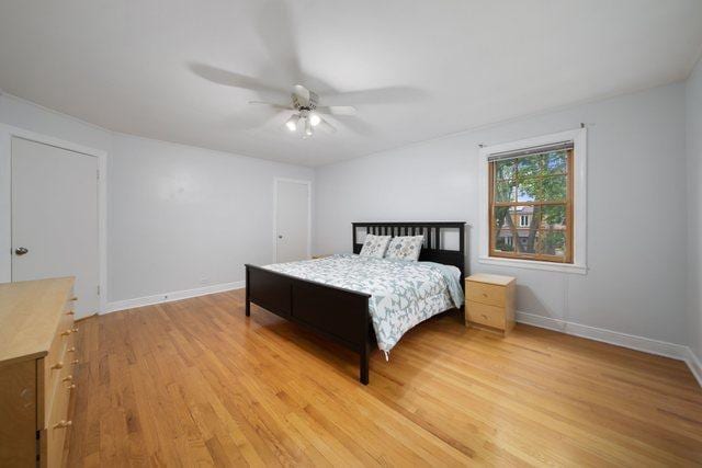 bedroom with ceiling fan, baseboards, and light wood-style flooring