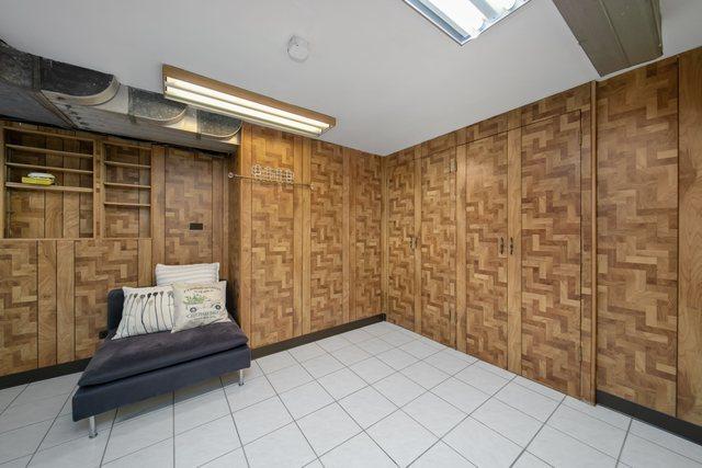 sitting room featuring wooden walls and light tile patterned flooring