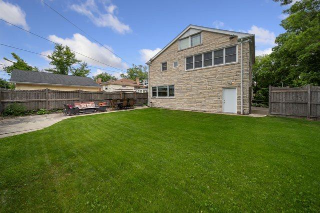 rear view of house with a patio area, a lawn, and a fenced backyard