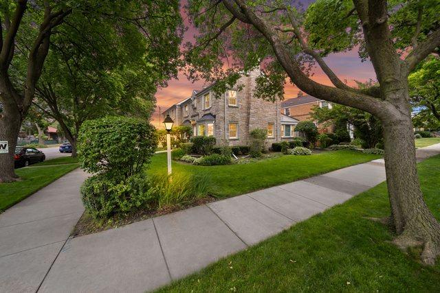 view of front of home featuring stone siding and a front lawn