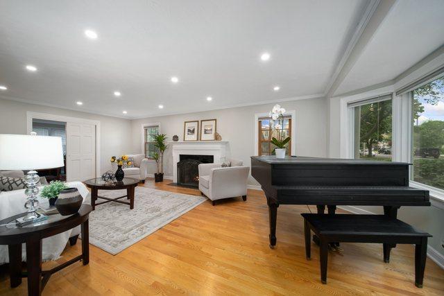 living room with recessed lighting, a fireplace with flush hearth, light wood-style flooring, and baseboards