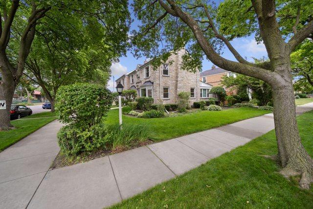 view of front of home with stone siding and a front lawn