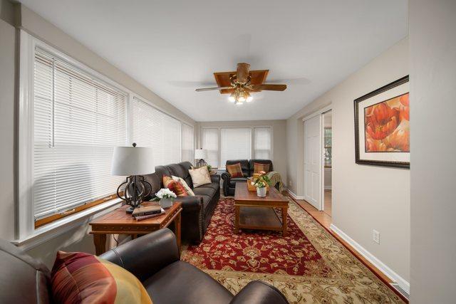 living area featuring a healthy amount of sunlight, baseboards, and ceiling fan