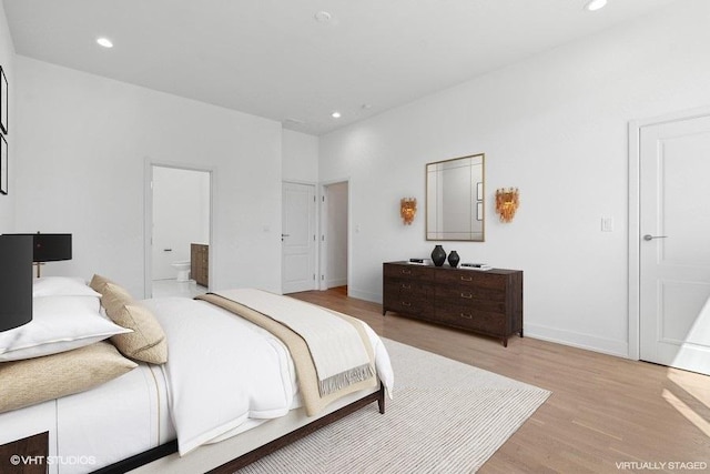 bedroom with ensuite bathroom and light hardwood / wood-style flooring