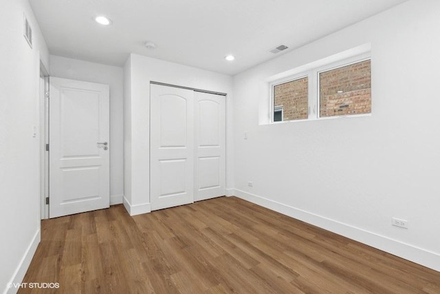 unfurnished bedroom with wood-type flooring and a closet