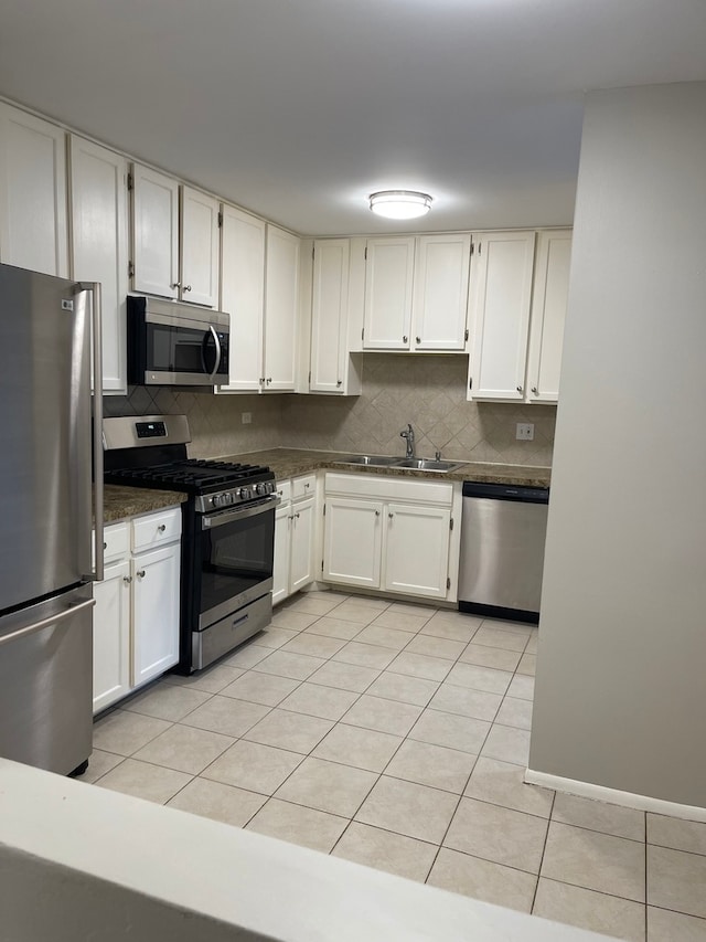 kitchen with white cabinets, stainless steel appliances, and tasteful backsplash