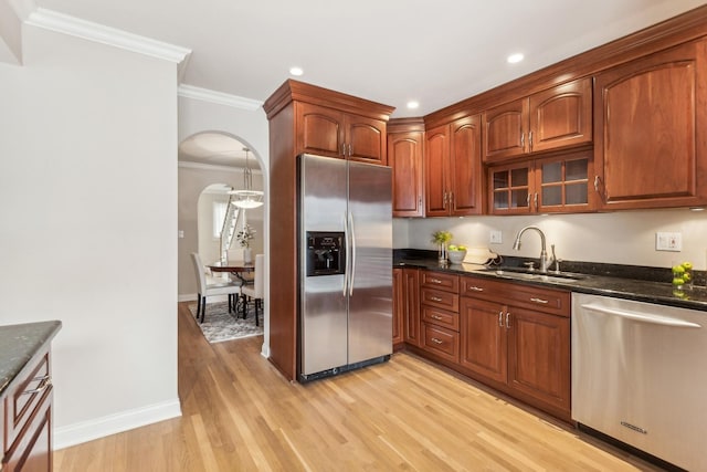 27 N Tower Rd Unit 27, Oak Brook, IL 60523 - kitchen with appliances with stainless steel finishes, a sink, arched walkways, light wood-style floors, and ornamental molding