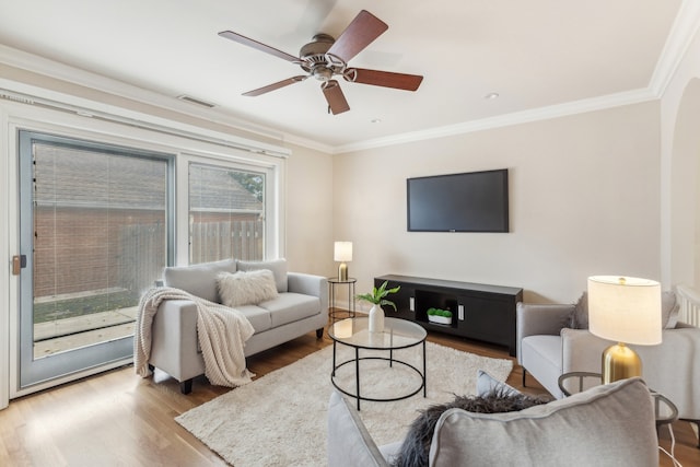 living room with ornamental molding, hardwood / wood-style flooring, and ceiling fan