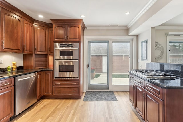 27 N Tower Rd Unit 27, Oak Brook, IL 60523 - kitchen featuring stainless steel appliances, light wood finished floors, dark stone counters, ornamental molding, and recessed lighting