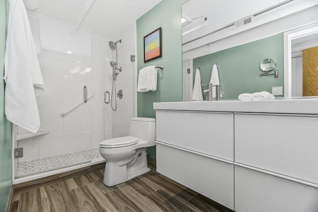 bathroom featuring hardwood / wood-style floors, vanity, an enclosed shower, and toilet