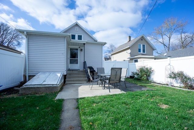 rear view of house featuring a patio area and a yard