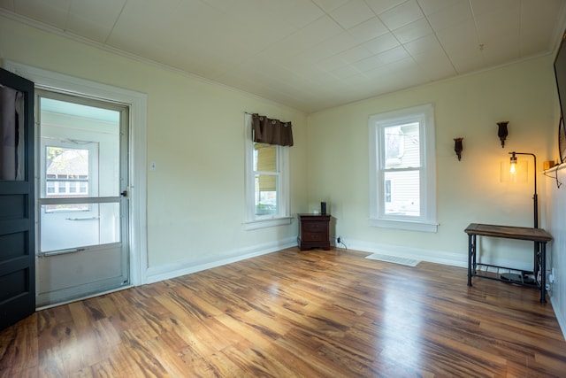 empty room featuring hardwood / wood-style floors and ornamental molding