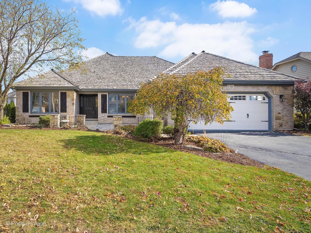 single story home with a front lawn and a garage