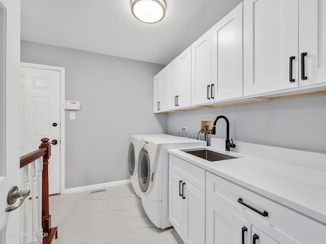 washroom featuring cabinets, sink, and separate washer and dryer