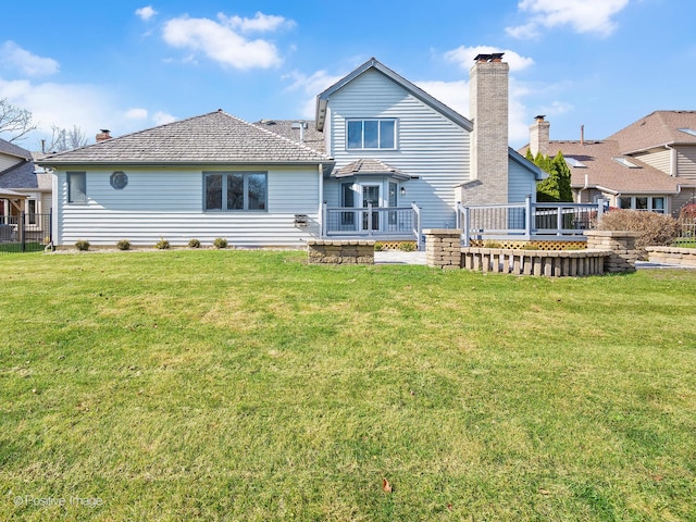 back of property with a wooden deck and a lawn