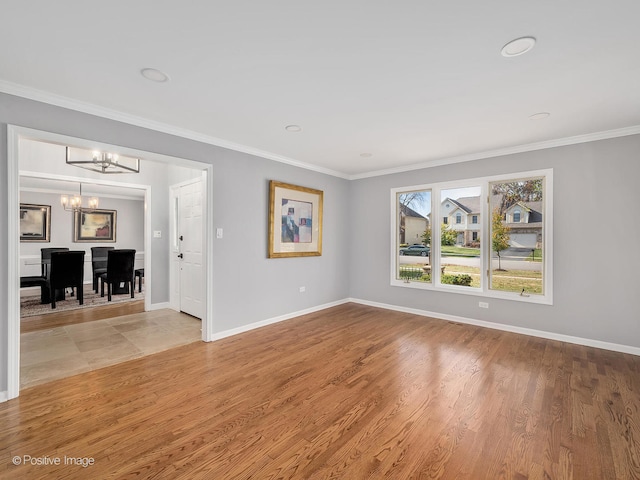 unfurnished living room featuring ornamental molding, a chandelier, and light hardwood / wood-style floors