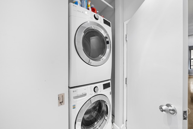 washroom featuring stacked washer and clothes dryer