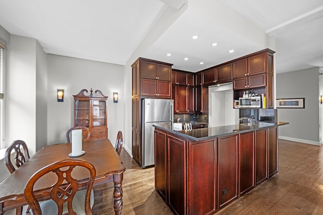 kitchen with hardwood / wood-style floors, decorative backsplash, and stainless steel appliances