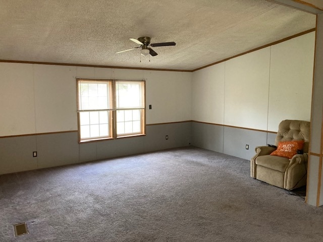 unfurnished room featuring light carpet, crown molding, a textured ceiling, and ceiling fan