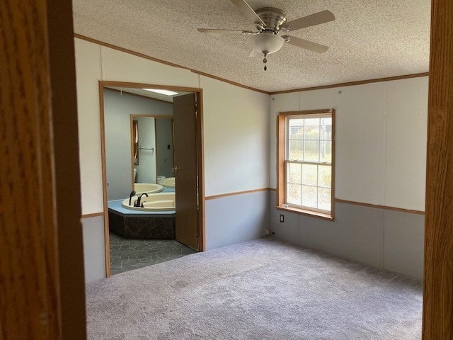 unfurnished bedroom with connected bathroom, carpet floors, crown molding, a textured ceiling, and ceiling fan