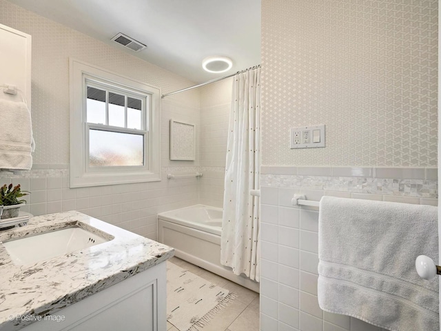 bathroom with tile walls, tile patterned flooring, vanity, and shower / tub combo with curtain