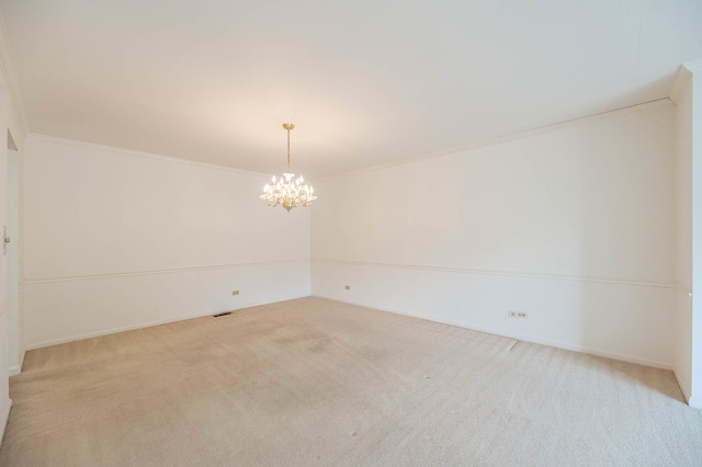 carpeted empty room with crown molding and a notable chandelier