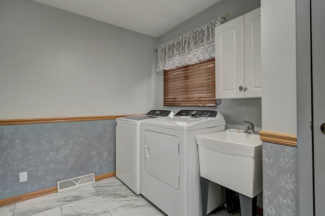 laundry area with sink, washer and clothes dryer, and cabinets