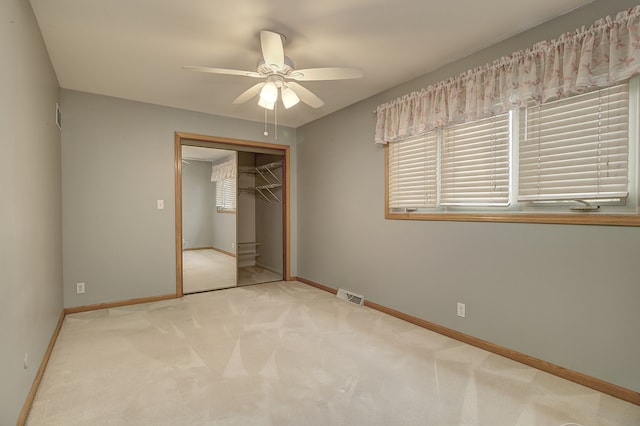 unfurnished bedroom with light carpet, a closet, and ceiling fan