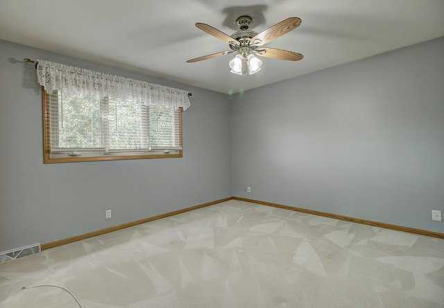 carpeted spare room featuring ceiling fan