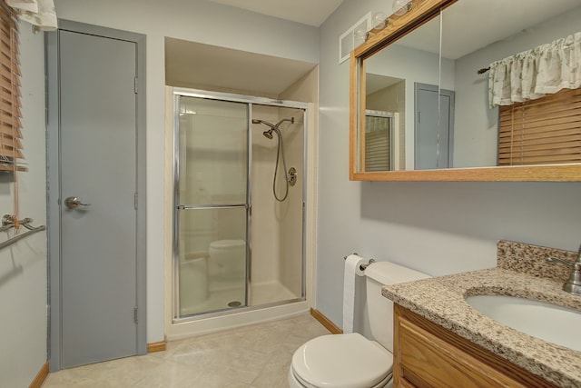 bathroom featuring vanity, walk in shower, toilet, and tile patterned floors