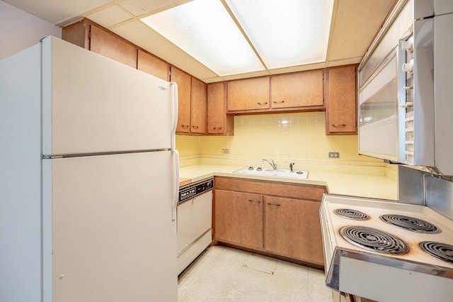 kitchen featuring tasteful backsplash, sink, and white appliances