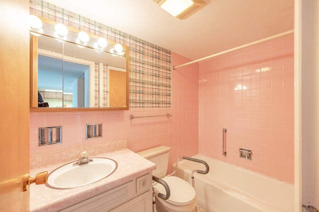 full bathroom featuring decorative backsplash, toilet, vanity, tiled shower / bath combo, and tile walls