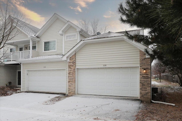 view of front of property featuring a balcony and a garage