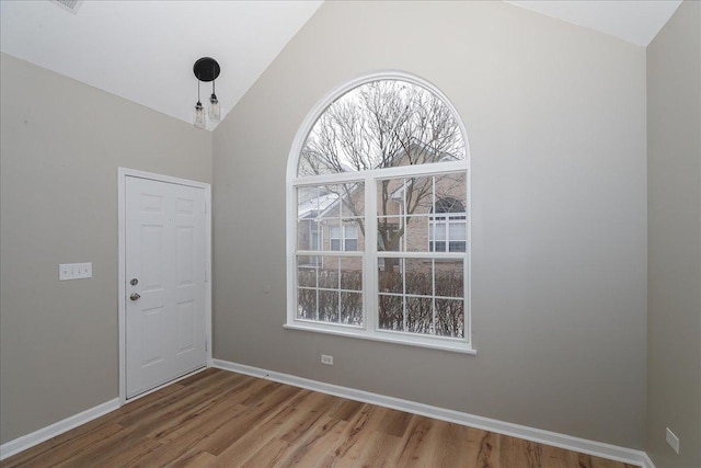 unfurnished room featuring vaulted ceiling and hardwood / wood-style floors