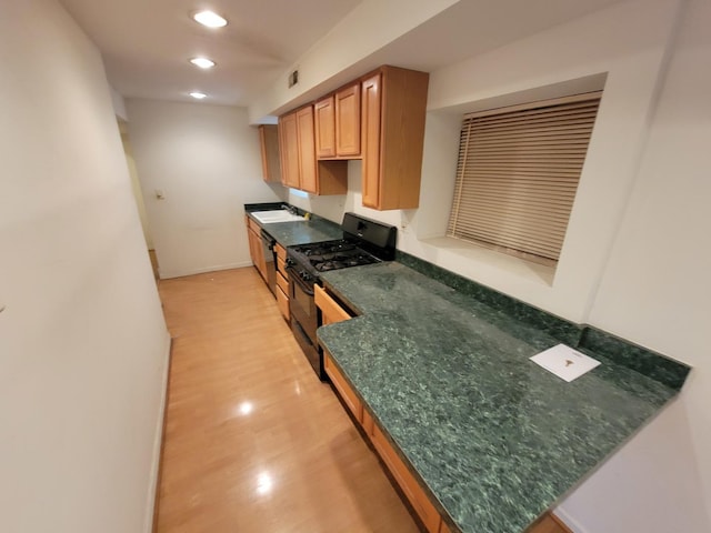 kitchen with black range with gas stovetop, dishwasher, and sink