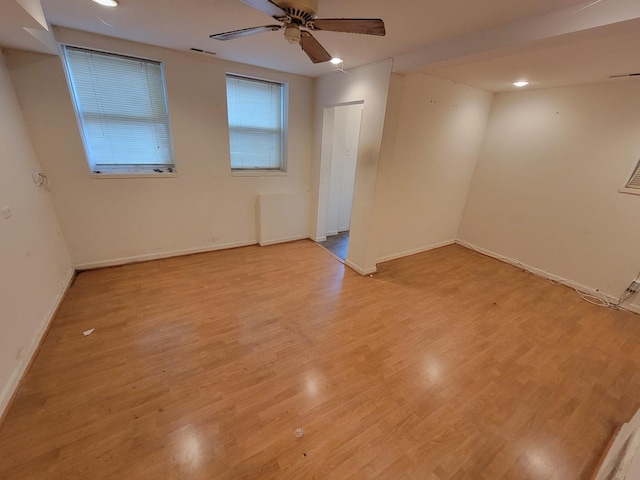 empty room with ceiling fan and light hardwood / wood-style flooring