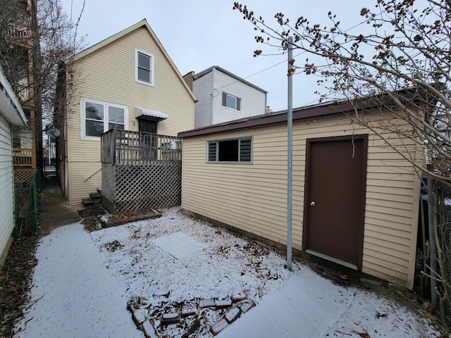 snow covered rear of property with a wooden deck