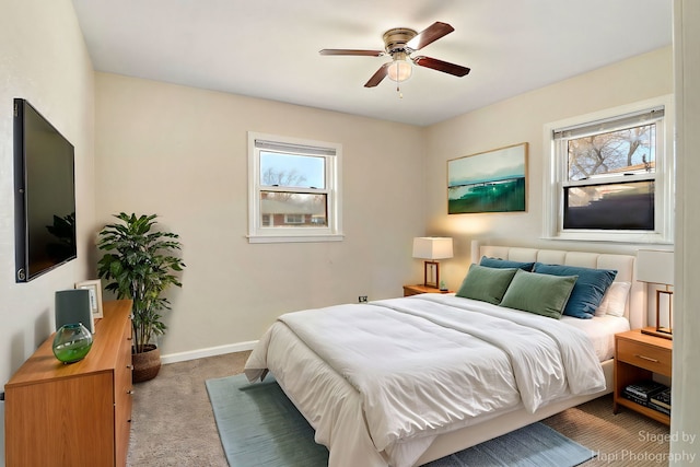 bedroom featuring multiple windows, light colored carpet, and ceiling fan