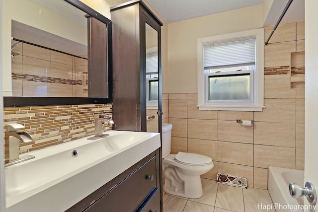 full bathroom with bathtub / shower combination, toilet, tile walls, vanity, and tile patterned flooring