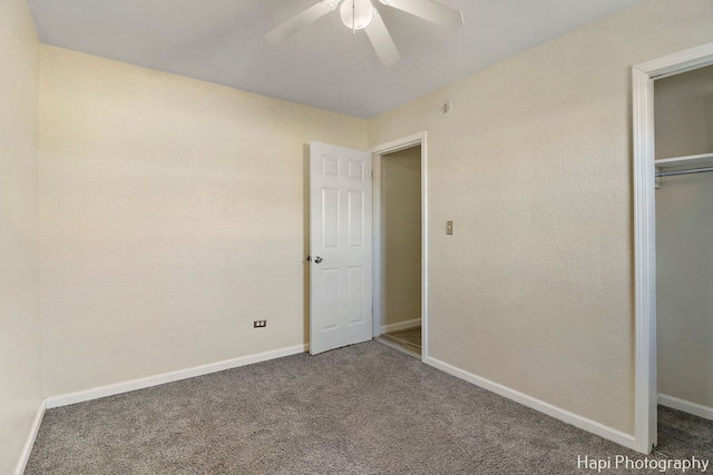 unfurnished bedroom featuring ceiling fan, a closet, and dark colored carpet