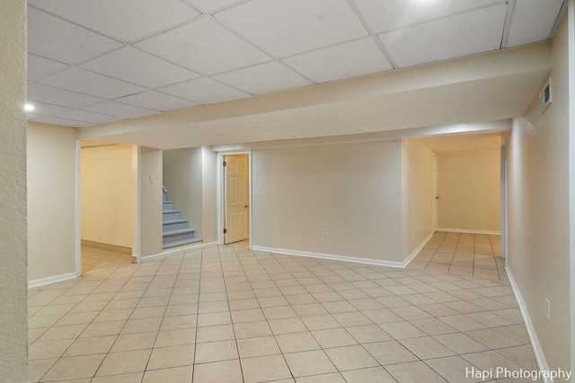 basement with light tile patterned flooring and a drop ceiling