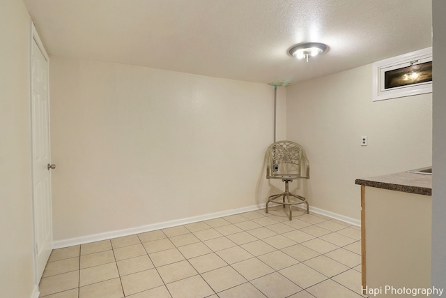 interior space featuring light tile patterned floors and a textured ceiling