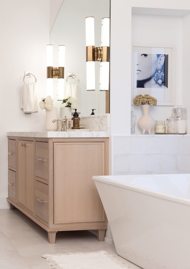 bathroom featuring vanity, a bath, and tile patterned flooring