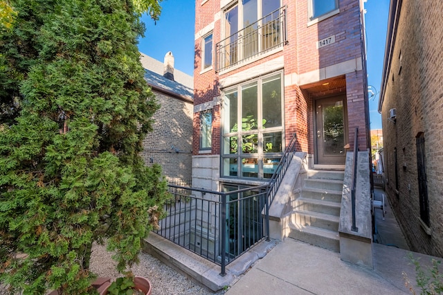 view of exterior entry featuring a balcony