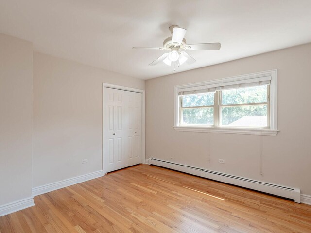 empty room with a wall unit AC, light hardwood / wood-style flooring, and a baseboard heating unit