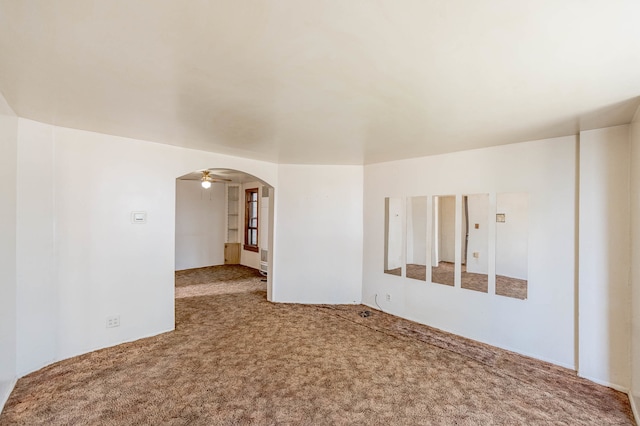 carpeted spare room featuring ceiling fan