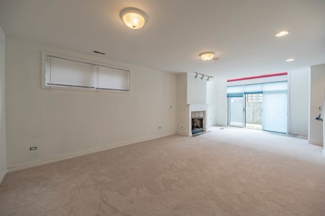 unfurnished living room featuring light colored carpet and a tile fireplace