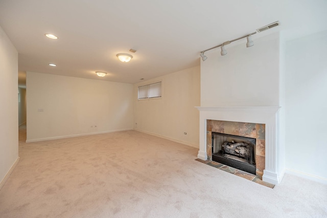 unfurnished living room with a tiled fireplace and light colored carpet